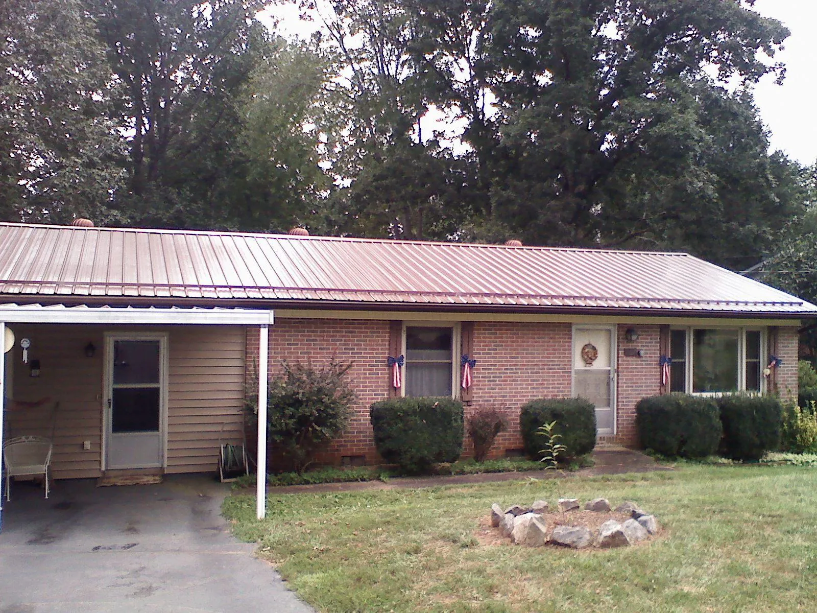 Bronze metal roof and carport on a brick ranch home — Roof Repair work by our crew in Andrews Air Force Base